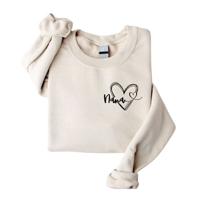 Beige Creme folded crewneck sweatshirt folded with Nana and heart on left chest sitting on white background. Little Gift Nook