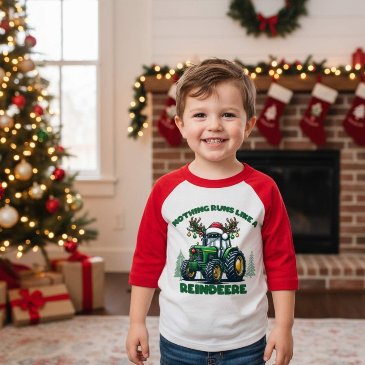 Little boy wearing red sleeve white reindeer "Nothing runs like a reindeer" Christmas shirt in front of Christmas background. 
