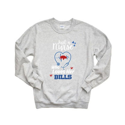 heather gray sweatshirt with white red and blue text "Just a nurse who loves her BILLS" and stethoscope with red buffalo in center of heartbeat. Shirt is laying on white background. 