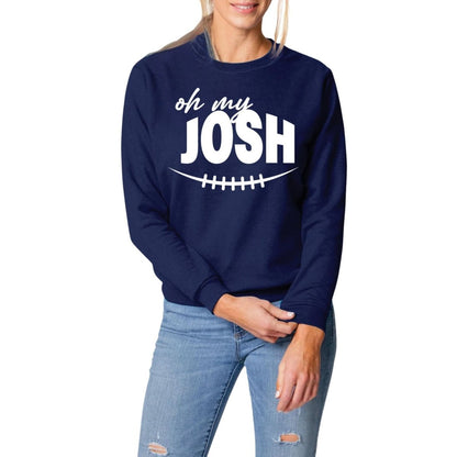 woman wearing navy sweatshirt with white Oh My Josh and football laces on front on a white background. Little GifT Nook