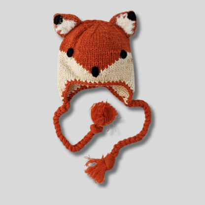 baby and toddler knit orange fox hat with braided tassels on light gray background. Little Gift Nook
