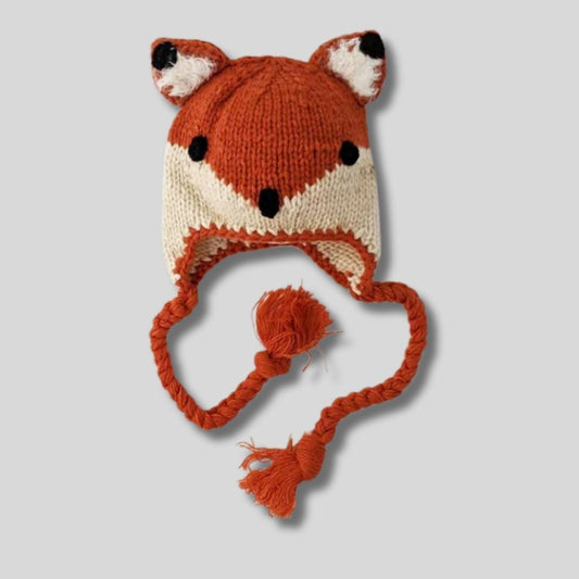 baby and toddler knit orange fox hat with braided tassels on light gray background. Little Gift Nook