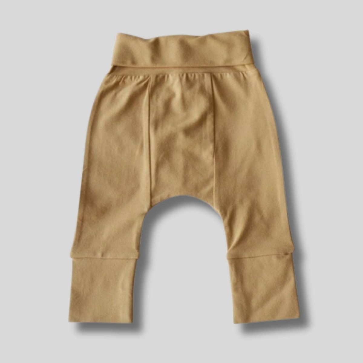Tan organic cotton baby pants laid flat on a light gray background.