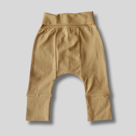 Tan organic cotton baby pants laid flat on a light gray background.