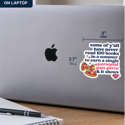 A humorous vinyl sticker applied to the side of a silver laptop. The sticker features a white background with blue and pink text reading 'some of y'all have never read 100 books in a summer to earn a single personal pan pizza & it shows' alongside illustrations of pepperoni and cheese pizza slices.