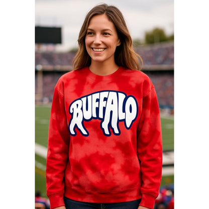 Woman wearing red bleach-dyed crewneck sweatshirt with blue & white buffalo letters in shape of buffalo on front standing on football field background.