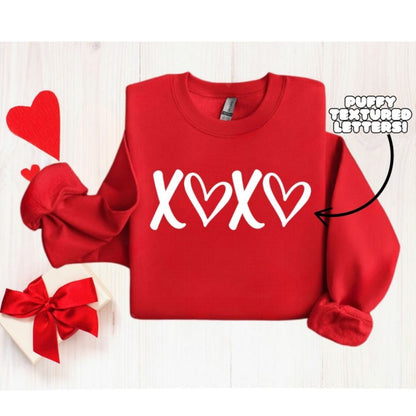 Red XOXO Puffy Letters Crewneck. Unisex fit fleece lined red crewneck sweatshirt with white textured puffy lettering xoxo on front. Makes cute gift. Little Gift Nook.