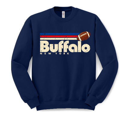 A navy blue crewneck sweatshirt featuring a distressed graphic on the chest with the text 'Buffalo NEW YORK', a football, and red and white stripes.
