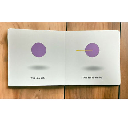 Open book "Rocket Science for Babies" with two pages showing purple balls and text on a wooden surface.
