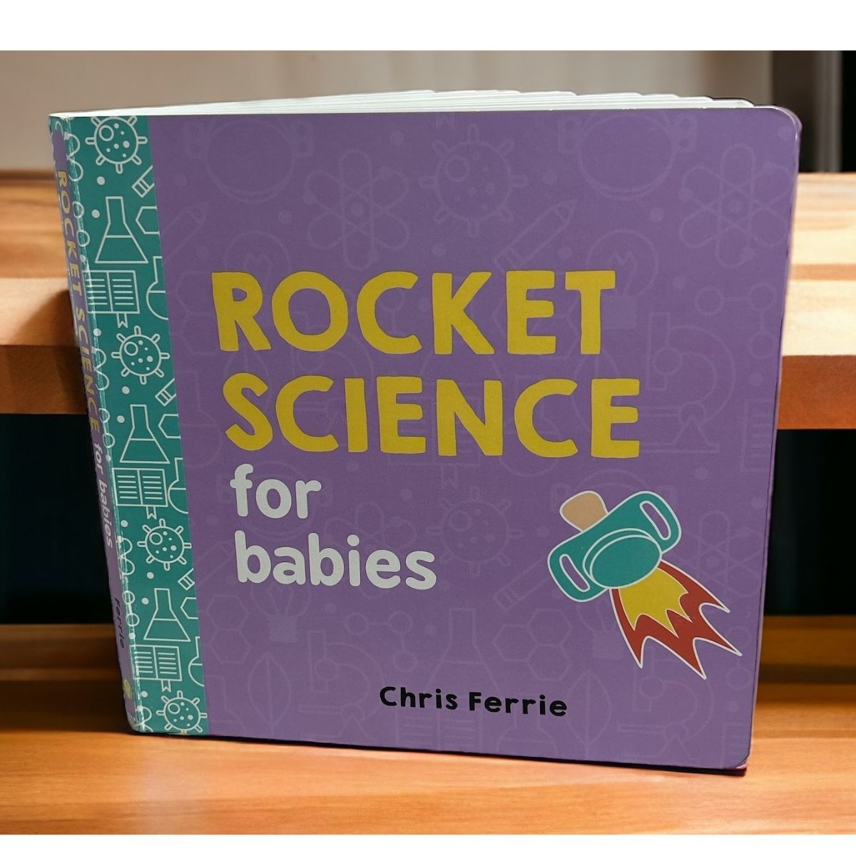 Book titled 'Rocket Science for Babies' by Chris Ferrie standing on a wooden surface.