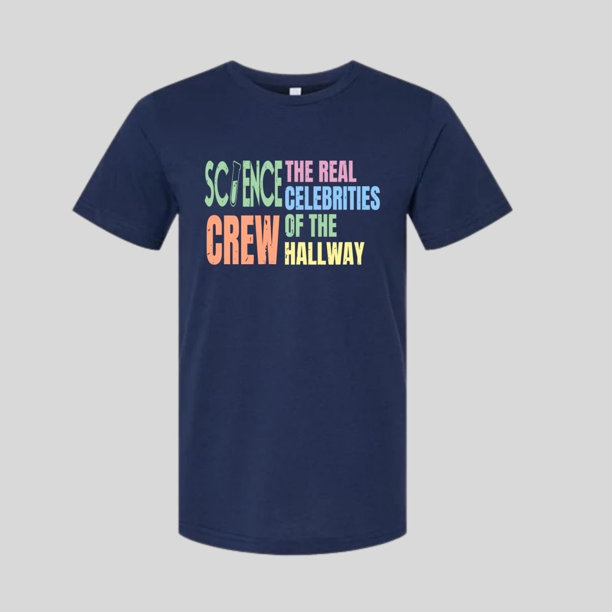 Navy t-shirt with pastel retro text "Science Crew The Real Celebrities of the Hallway" on front laying flat on gray background. Little Gift Nook