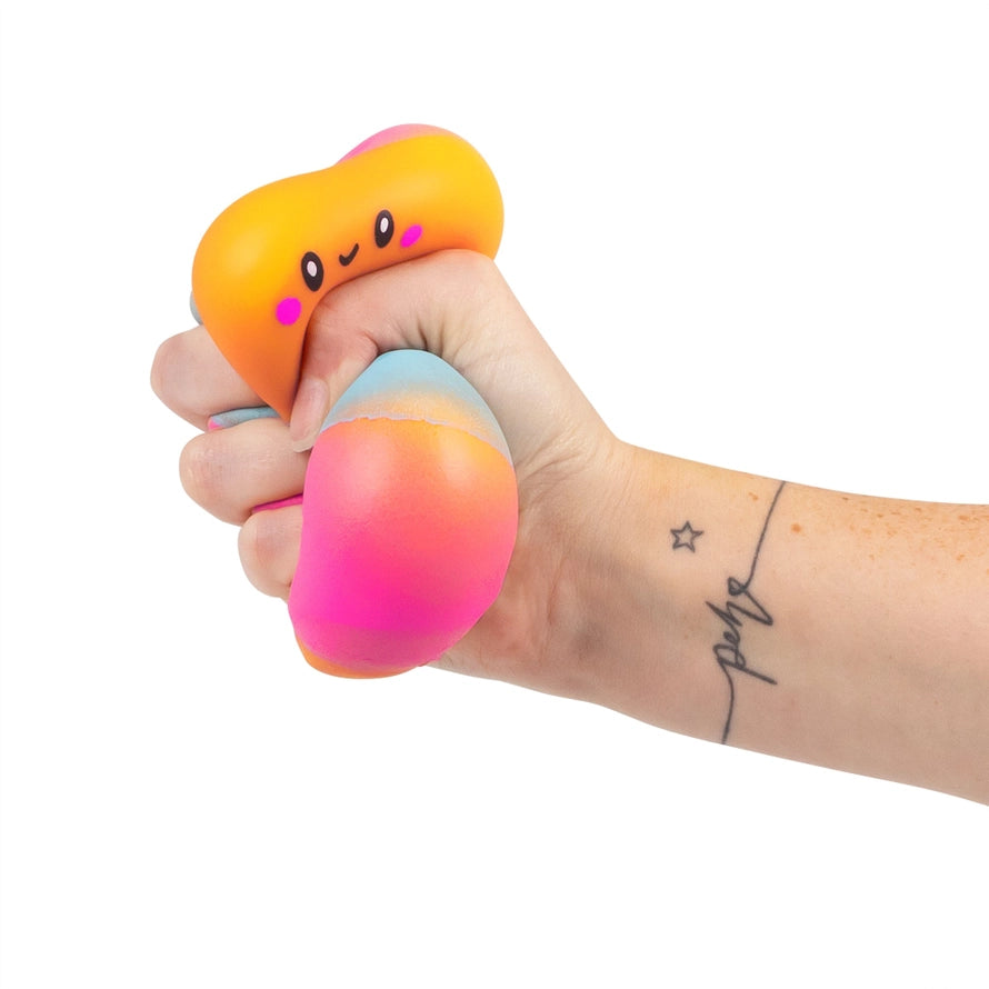 Hand squeezing Srunchems colorful orange blue and pink striped squishy marshmallow like sensory fidget squeezy toy on a white background.