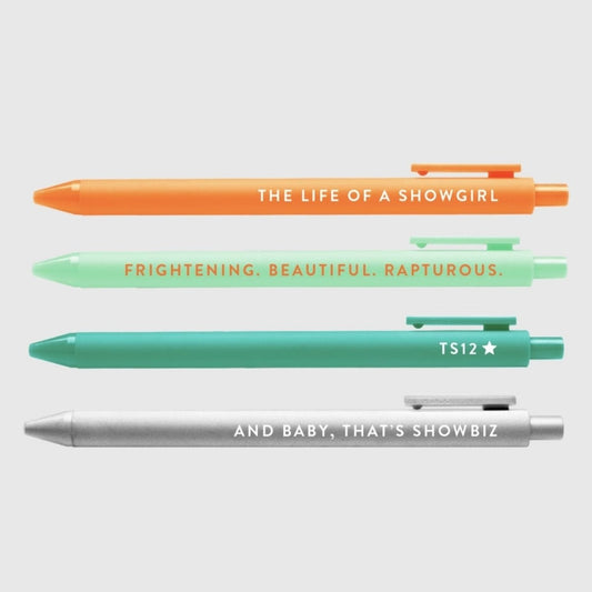 Showgirl Taylor inspired 4 pack gel pen set in orange, greens, and silver with phrases on each sitting on gray background. Little Gift Nook
