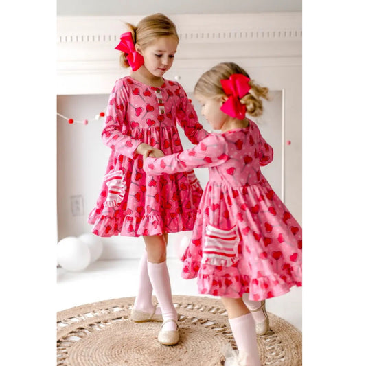 Sucker for Love Hearts Ruffle Twirl Dress. Pink ruffle dress with dark pink heart sucker print and 2 front striped pockets with ruffle edges.  - Little Gift Nook