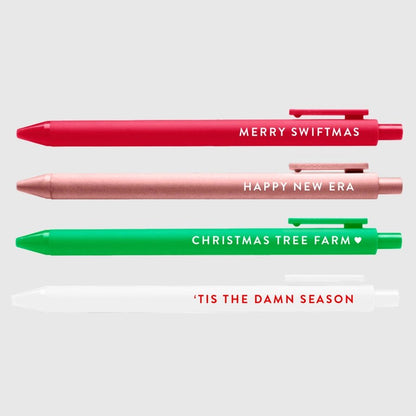 Swiftmas 4 gel pen set in red, pink, green, and white with lyrics on each pen sitting on light gray background.  Little Gift Nook