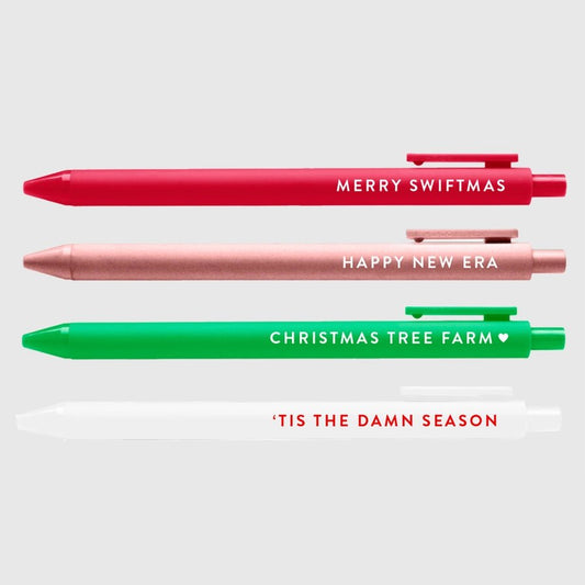 Swiftmas 4 gel pen set in red, pink, green, and white with lyrics on each pen sitting on light gray background.  Little Gift Nook