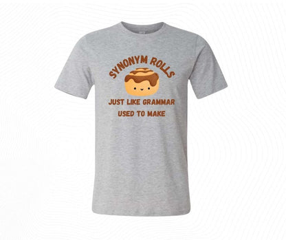 Gray t-shirt with Cartoon cinnamon roll with text 'SYNONYM ROLLS JUST LIKE GRAMMAR USED TO MAKE' image download.