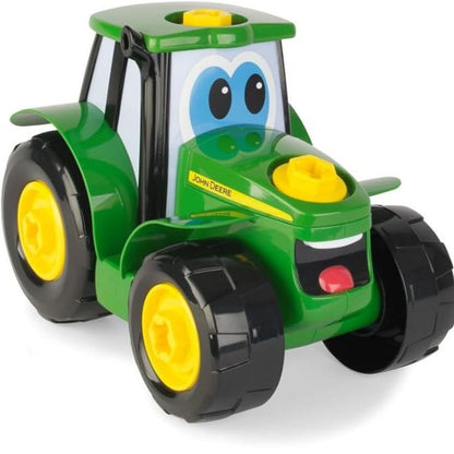 Close up of John Deere tractor toy put together sitting on white background. 