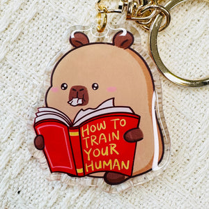 Capybara reading book how to train your human acrylic keychain.  Little Gift Nook.