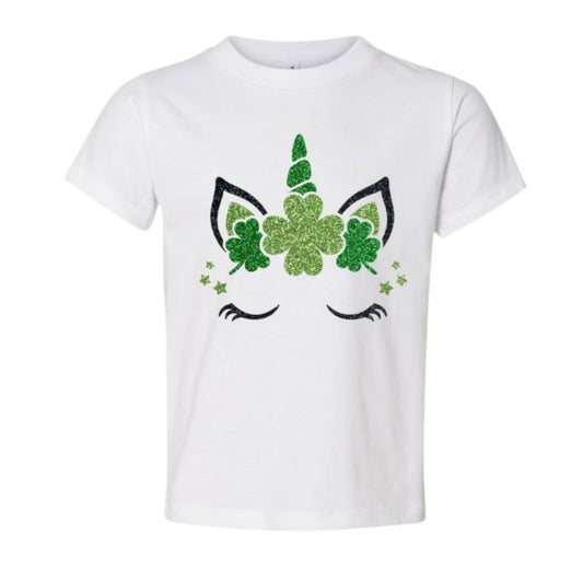 White tshirt with glitter clover unicorn face and horn sitting on white background. Little Gift Nook