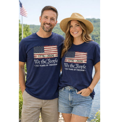 Man and Woman wearing navy USA Flag 1776-2026 We the people 250 years of freedom shirt outdoors.