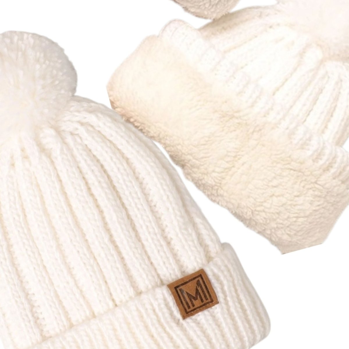 White knit beanie pom hat close up with sherpa lining on a white background.