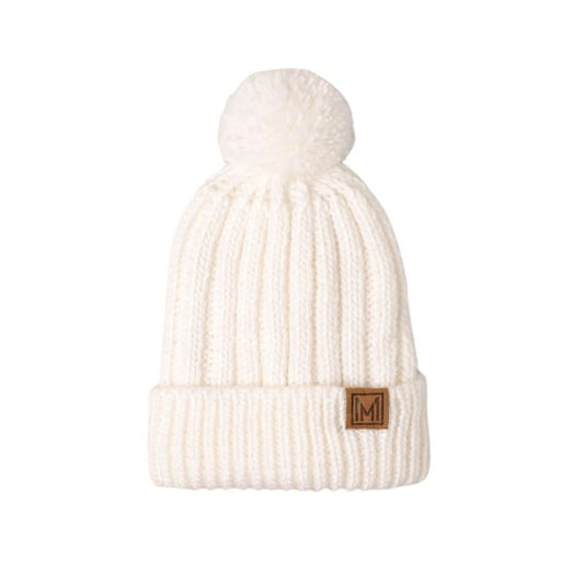 White knit beanie with pom-pom and brand logo laying on white background.