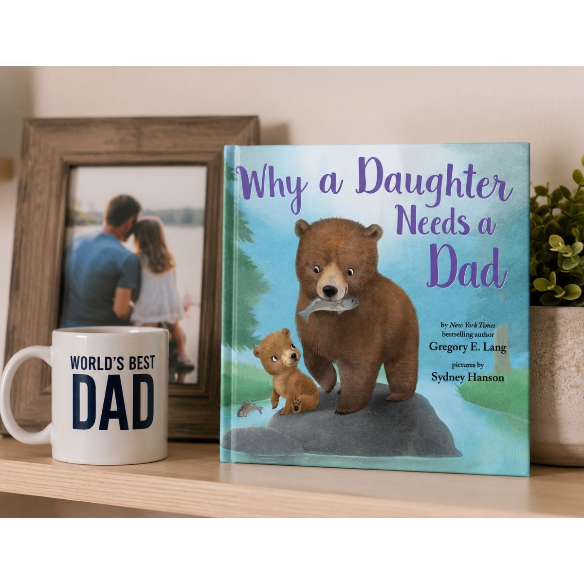 Book titled 'Why a Daughter Needs a Dad' on a wooden shelf with a mug labeled 'World's Best Dad'.