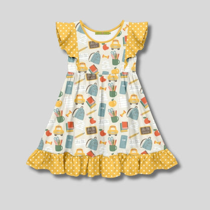 Children's dress with school-themed print and yellow polka dot details on a gray background. Little Gift Nook.