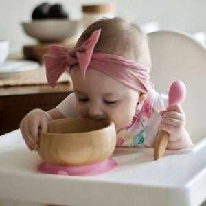 Bamboo baby suction bowl with spoon gift set. baby model eating out of non slip suction bowl.