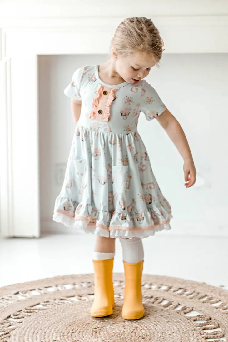 Honey Bunny Blue Eyelet Twirl Dress. Little girl in light baby blue dress with pink ruffles and bunny print. 2 front pockets.  - Little Gift Nook