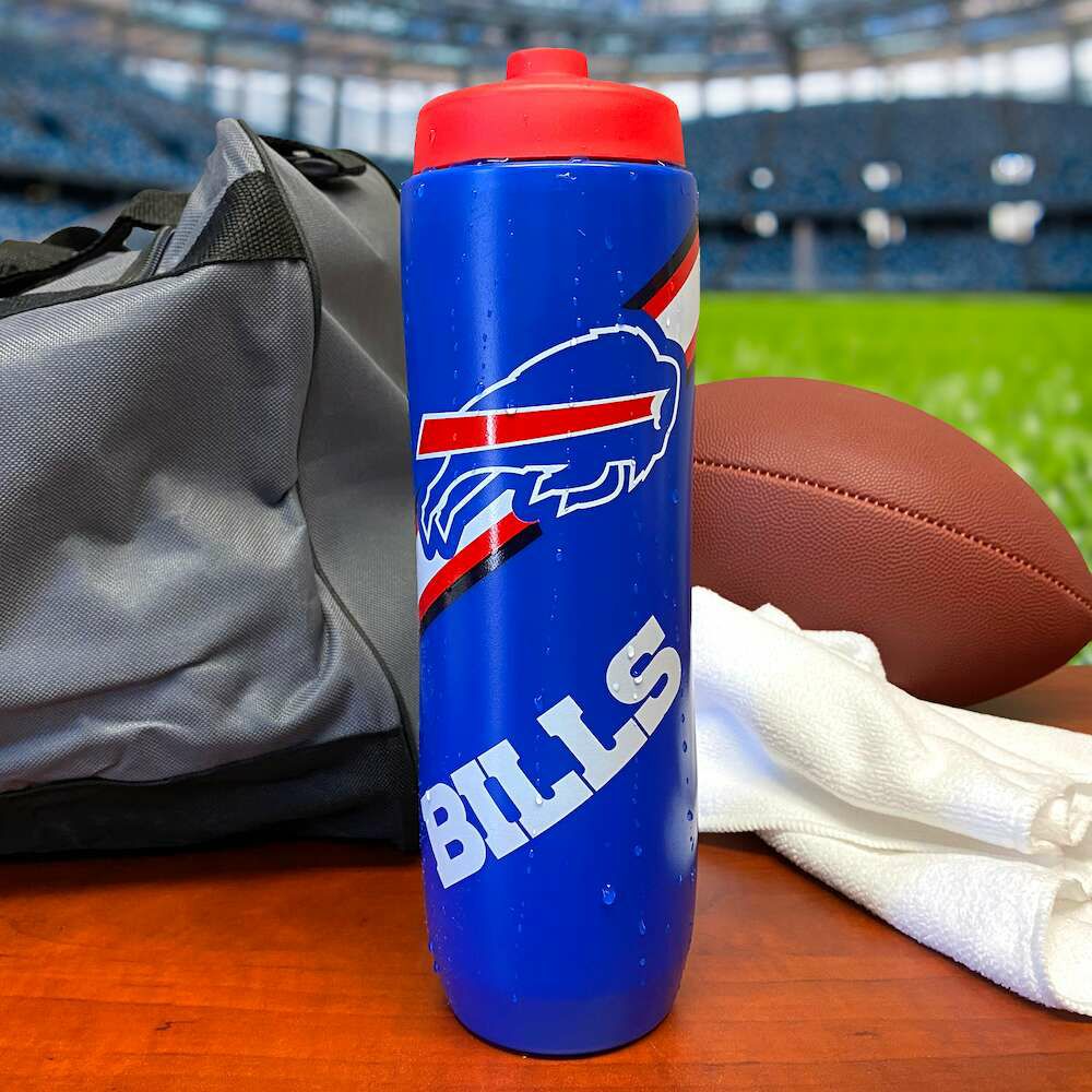 Buffalo Bills Squeezy Water Bottle BPA Free 32oz. Water bottle is royal blue with red cap and bills logo on front.  Shown with football on field.- Little Gift Nook