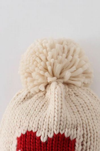 Close up of pom pom on Cream Knit Heart Beanie Pom Pom Baby Hat.  - Little Gift Nook