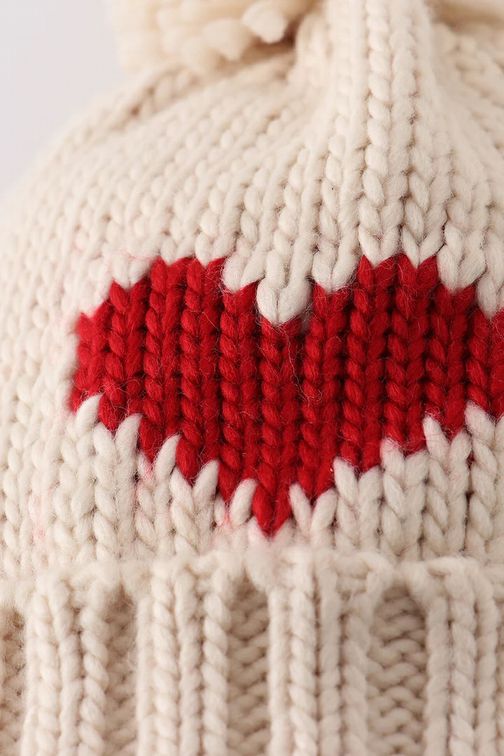 Close up of front of Cream Knit Red Heart Beanie Pom Pom Baby Hat - Little Gift Nook