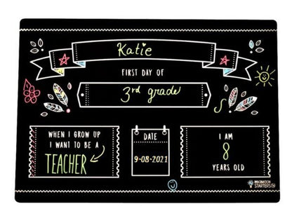 Imagination Starters black plastic wipe off First Day of School Grade filled out placemat board sitting on a white background. 