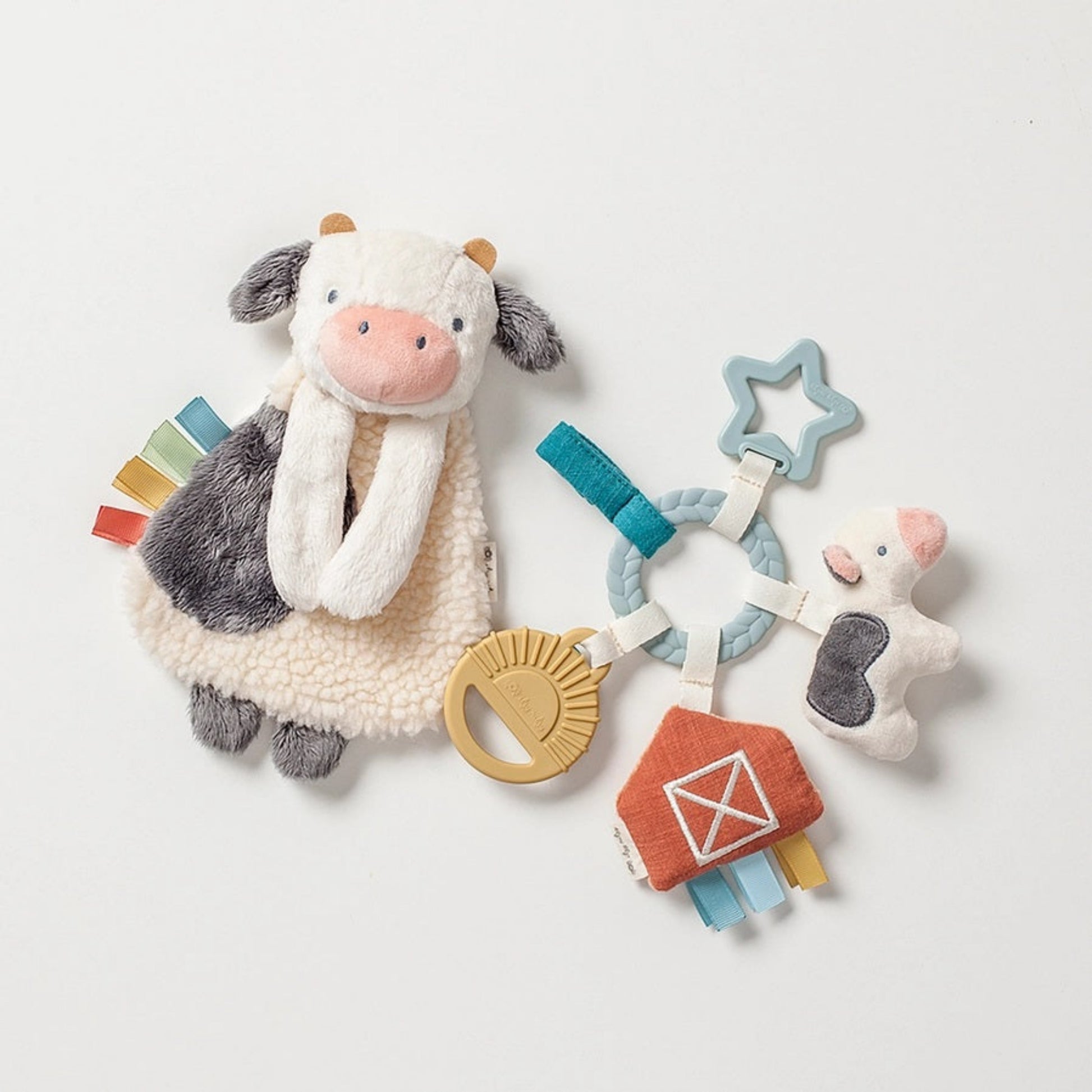 Itzy Ritzy Bitzy Busy Farm Baby Gift Set. Includes plush soft textured cow with taggies on side, Silicone teethers and more plush cow and barn plushies attached to a ring. - Little Gift Nook