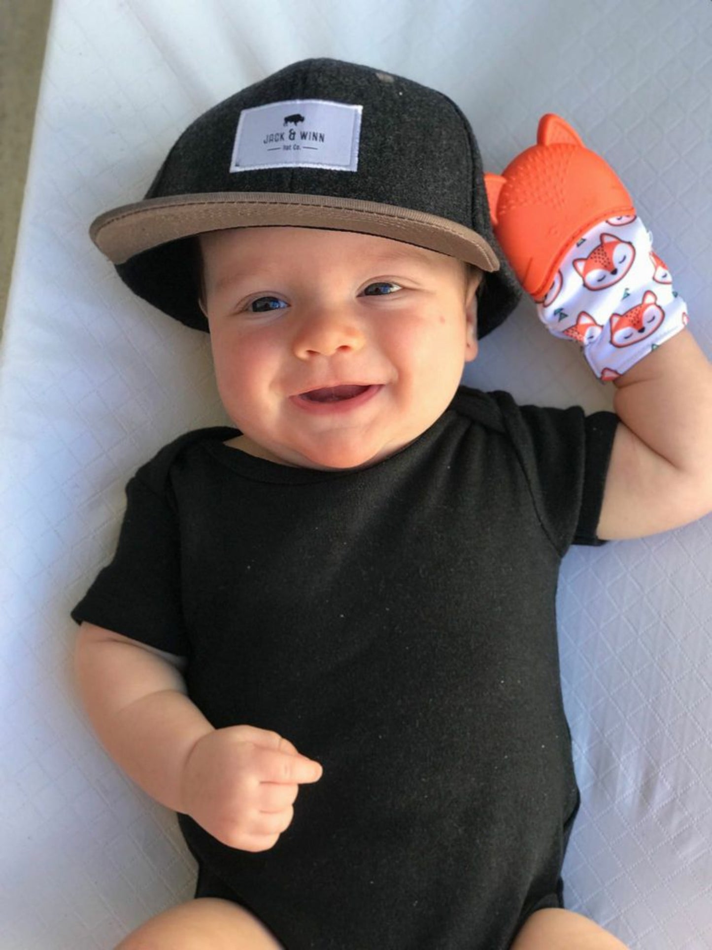 Baby with Itzy Ritzy Teething Mitt Orange Fox on his hand. Silicone teether top and textured crinkled mitt. - Little Gift Nook