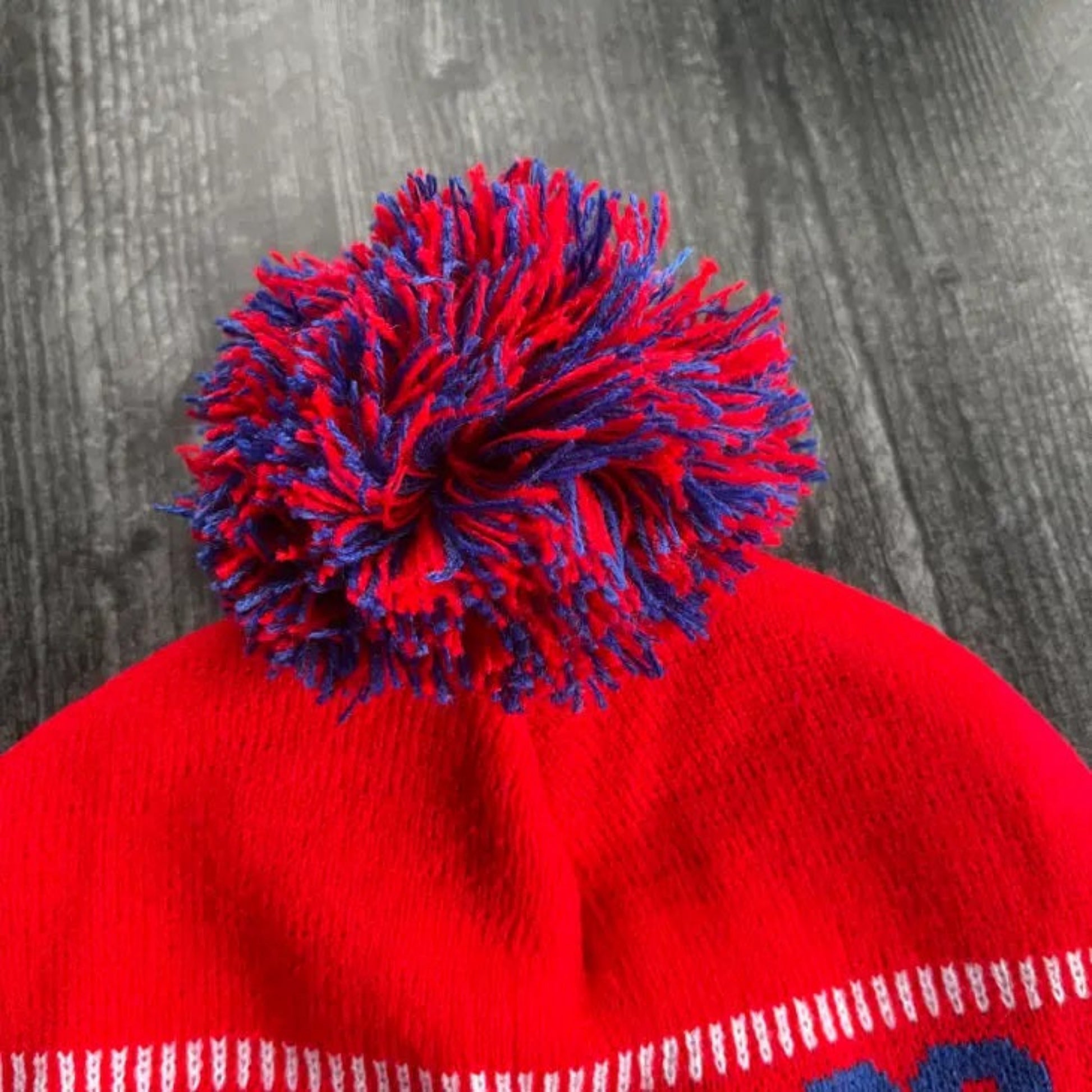 Let’s Go Buffalo red knit Adult Winter Hat. Close up of red and blue pom pom - Little Gift Nook