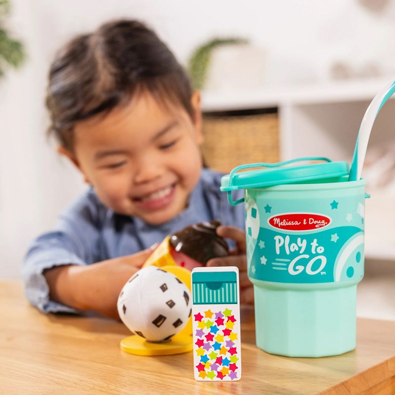 Child playing with the Melissa & Doug Play to Go Ice Cream Play Set. Make pretend ice cream treats.- Little Gift Nook
