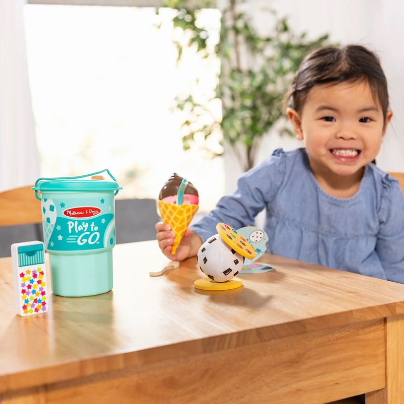 Child playing with Melissa & Doug Play to Go Ice Cream Play Set making ice cream cones. - Little Gift Nook