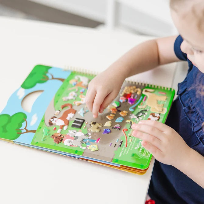 Melissa &amp; Doug Puffy Pet Place Reusable Sticker Activity Book. Showing child using stickers on page of booklet. - Little Gift Nook