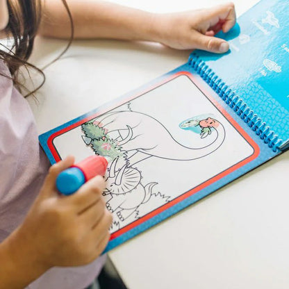 Melissa & Doug Water Wow Dinosaurs activity pad. Child using water pen and coloring dino picture in activity pad. Colors reveal when wet. - Little Gift Nook