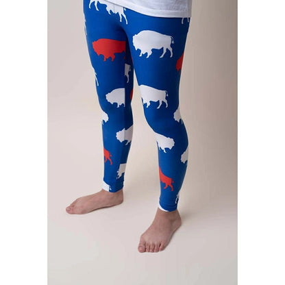 big kid wearing royal blue, red, and white buffalo print leggings on tan background. 