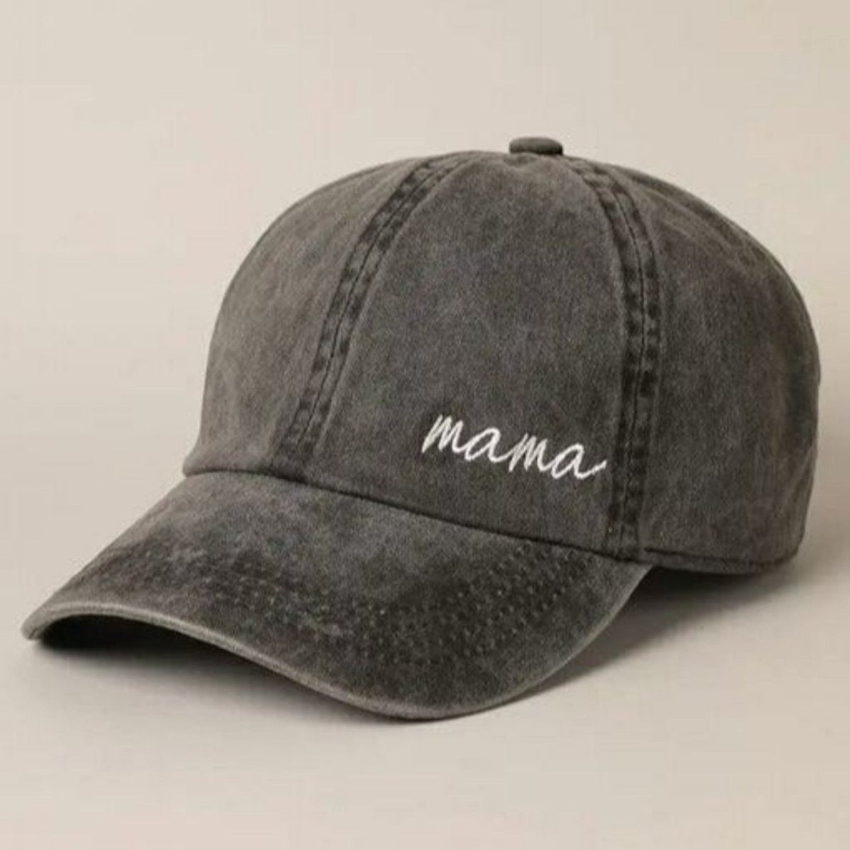 Mama cursive embroidered on bottom left of black cap hat sitting on light gray background.