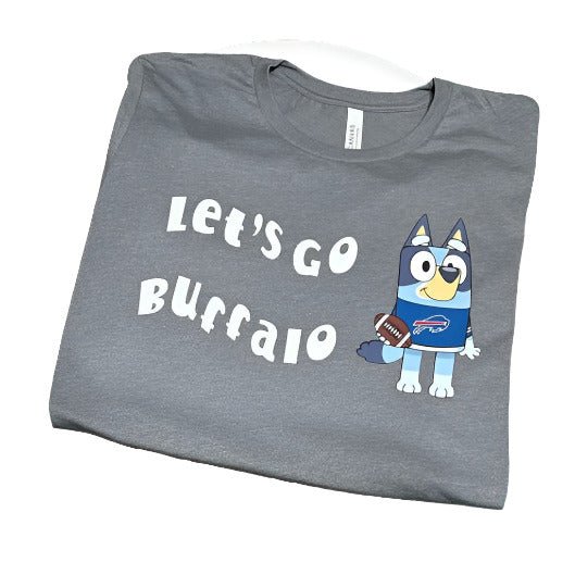 Dark gray adult tshirt with Let's Go Buffalo in white lettering and blue dog wearing jersey and holding a football on front sitting folded on white background. 
