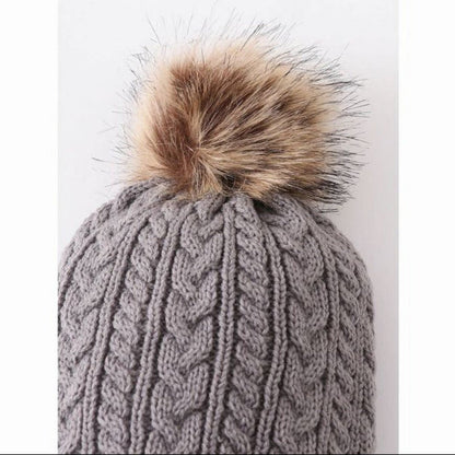 Close up of Grey cable knit child beanie hat pom pom at top of hat. Faux fur pom pom.- Little Gift Nook