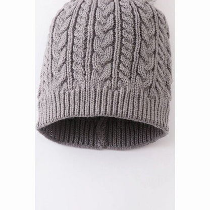 close up of gray cable knit child's hat on white background.
