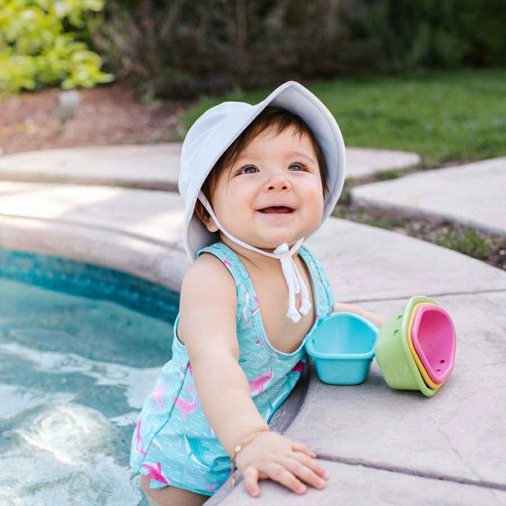 iPlay White Breathable Bucket Sun Hat. UPF 50+. Hat shown on little baby in pool.  Baby through toddler sizes.- Little Gift Nook