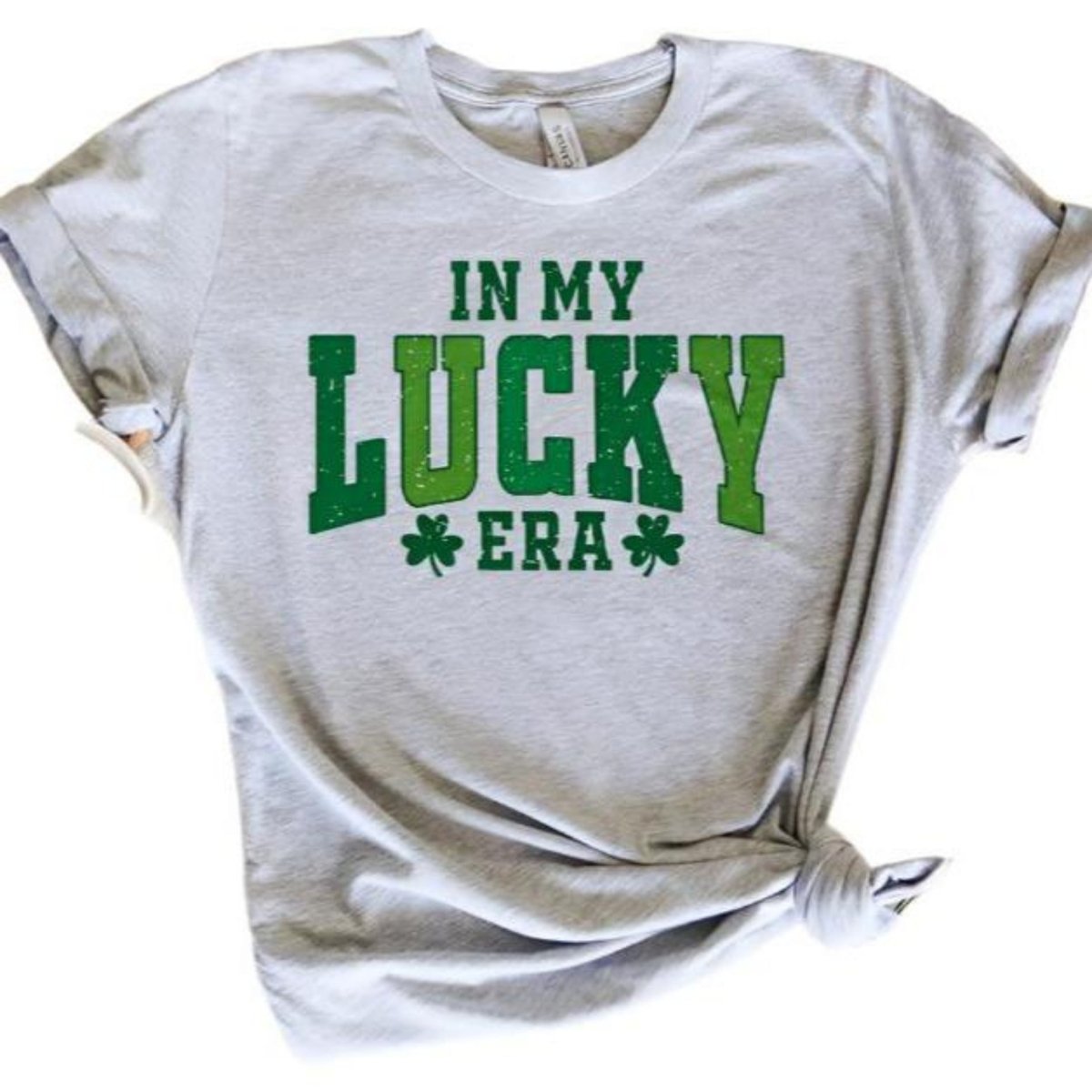 Heather gray tshirt with green text "In My Lucky Era" with green clovers on front on a white background.