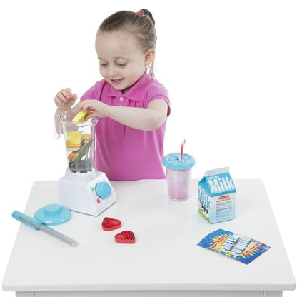 Little girl playing with Melissa & Doug pretend play blender smoothie maker on table on white background.